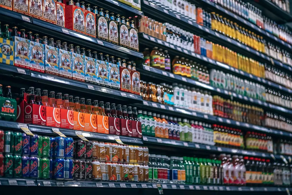 Bouteilles de e-liquides colorées alignées sur une étagère de magasin spécialisé