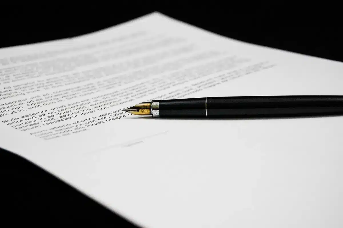 Documents réglementaires et papier sur un bureau éclairé par la lumière du jour