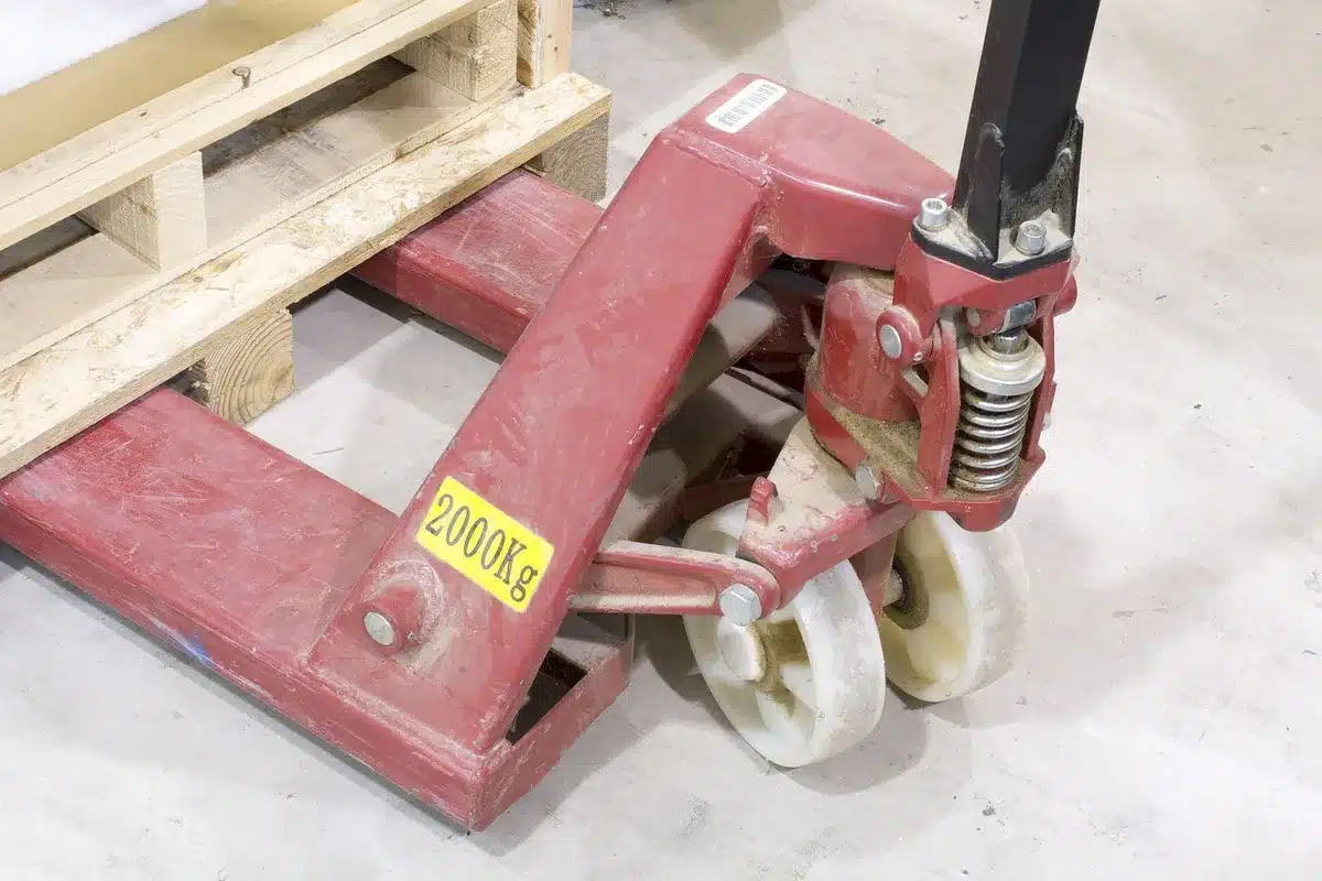 Palette de cartons et conteneurs près d'une usine, symbolisant l'importation